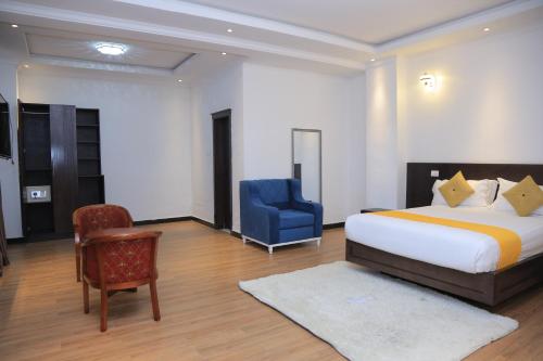 a bedroom with a bed and a blue chair at yellow apple hotel in Addis Ababa