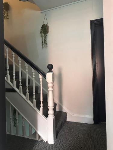 a stairway with white walls and a white stair case at Budget Rooms Lincoln City Centre , Fast WiFi & Self Check in in Lincoln