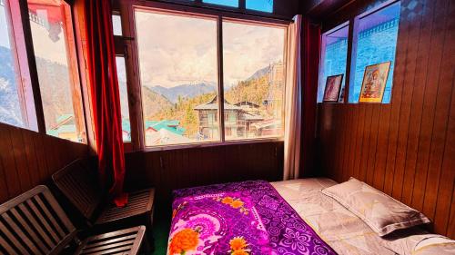 a bedroom with a bed in a room with a window at Dolma Homestay By Orko in Nachar