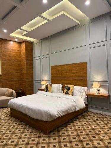 ein Schlafzimmer mit einem großen Bett und zwei Tischen in der Unterkunft Hotel Vintique in Lahore