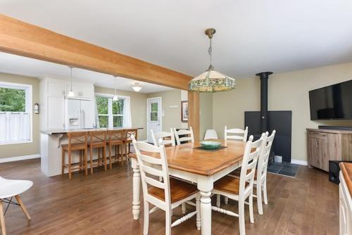 a kitchen and dining room with a wooden table and chairs at Ideal getaway - Ideal retreat in Lac-Brome