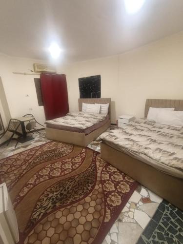two beds in a room with a rug at Sneferu hotel pyramids View in Cairo