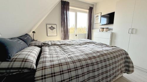 a bedroom with a bed with a plaid blanket at Wohnung Koje ³ in Böhl