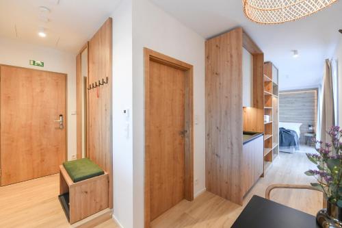 a room with a hallway with wooden doors and a table at Hotel Monínec - Depandance Apartmány in Moninec