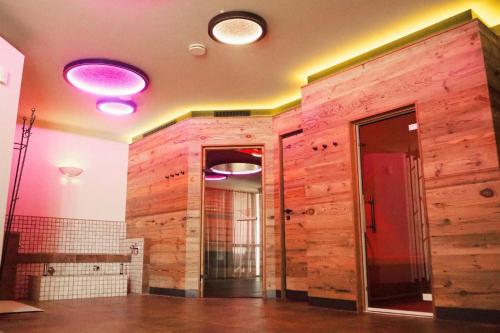a bathroom with a wooden wall with lights on it at Der Wieshof in Riedlhütte