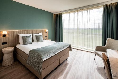 a bedroom with a bed and a large window at OZO Hotels De President Amsterdam Schiphol Airport in Hoofddorp