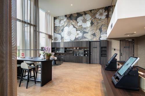 a dining room with a table and a kitchen at OZO Hotels De President Amsterdam Schiphol Airport in Hoofddorp