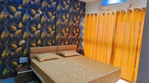 a bedroom with a bed and a wall with a mural at The Aura stays in Indore