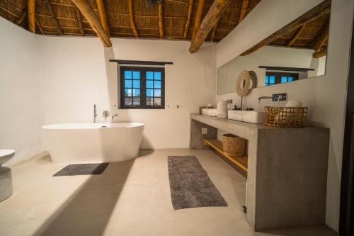 a bathroom with a large tub and a sink at De Wildeveldt in Darling