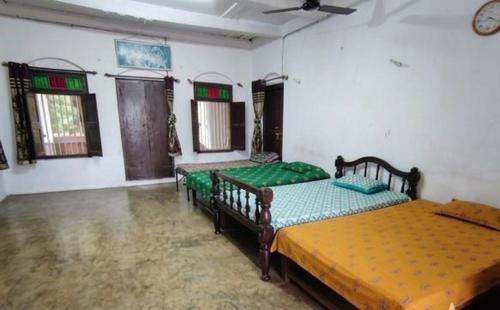 a bedroom with two beds in a room at Vikram homestay in Malvan