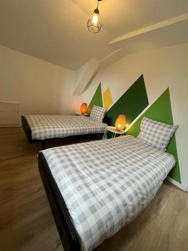 zwei Betten in einem Zimmer mit Grün und Weiß in der Unterkunft Raiv in Lectoure