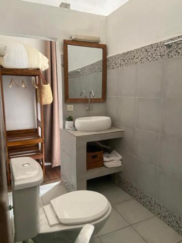 a bathroom with a toilet and a sink and a mirror at M'Serenity Guest House in Antananarivo