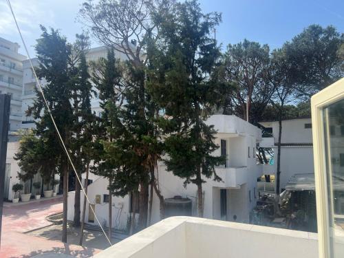 a tree in front of a white building at ApartHotel XH in Golem
