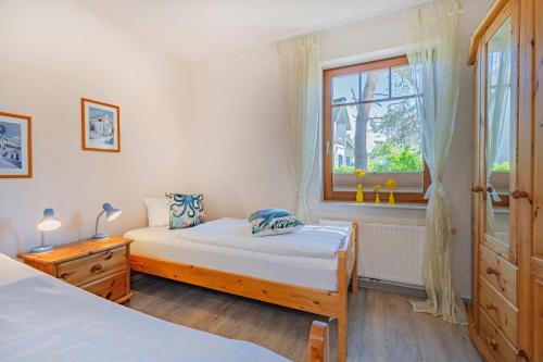 a bedroom with two beds and a window at Ferienwohnung Wassermann in Loddin
