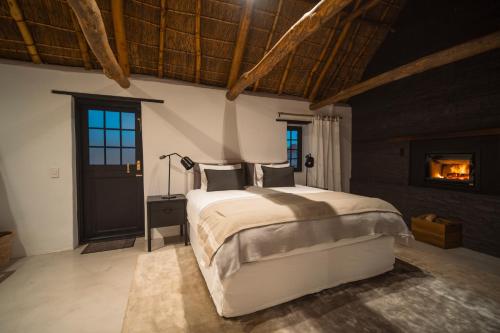 a bedroom with a large bed and a fireplace at De Wildeveldt in Darling