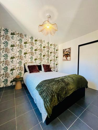 a bedroom with a bed and a chandelier at L'Escale paisible in Gardanne