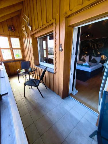 a room with a balcony with a chair and a bed at Ferienwohnung Burgperle Burghausen nahe weltlängster Burg zentral 24h Check in in Burghausen
