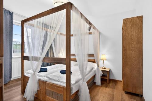 a bedroom with a canopy bed with white drapes at Resort Rybníček in Blatnice