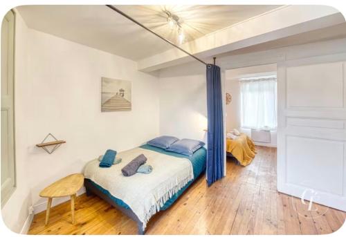 a bedroom with a bed with blue pillows on it at les Renardeaux maison cosy idéal PRO CNPE PIPA et Familles in Ambutrix