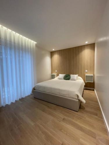 a bedroom with a bed and a large window at Areias do Norte in Póvoa de Varzim