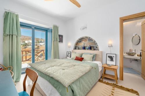 a bedroom with a bed and a large window at Ikos Kythnos in Kithnos