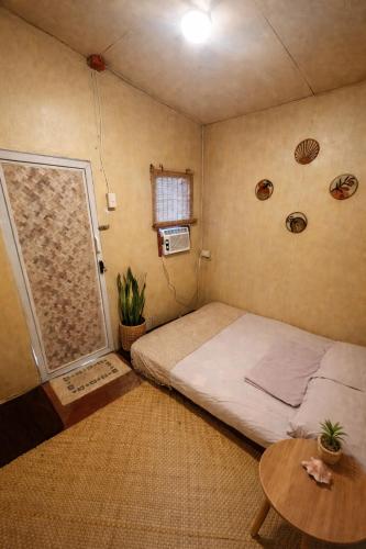 a small room with a bed and a table at The Stoke Hideout Bagasbas Beach in Daet