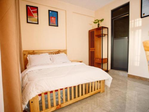 a bedroom with a large bed with white sheets at Kiliscape Hotel Moshi in Uru