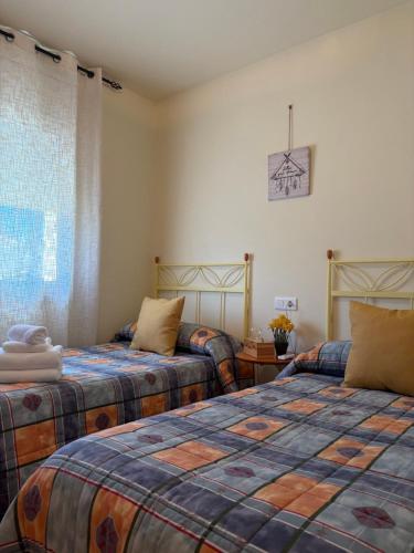 a bedroom with two beds and a window at Casa Campanilla in Riumar