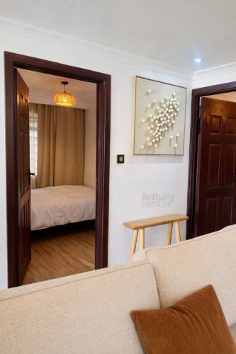 a living room with a couch and a bedroom at Kisii cottage in Kisii