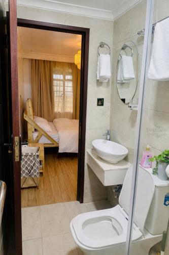 a bathroom with a toilet and a sink and a bed at Kisii cottage in Kisii