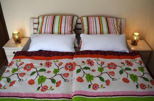 a bed with two pillows and a blanket on it at Sódomb vendégház in Egerszalók