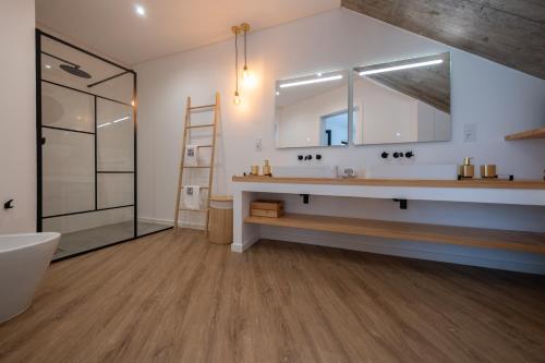a bathroom with a sink and a mirror at Chez Nous I e II in Caloura