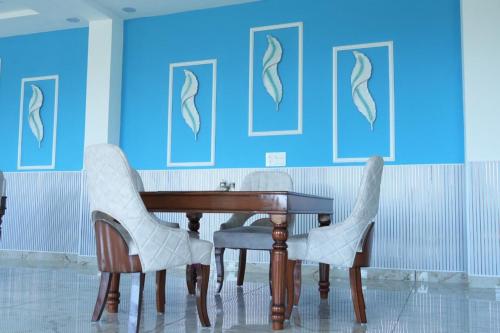 a table and chairs in a room with blue walls at Hotel Griffin in Kīratpur
