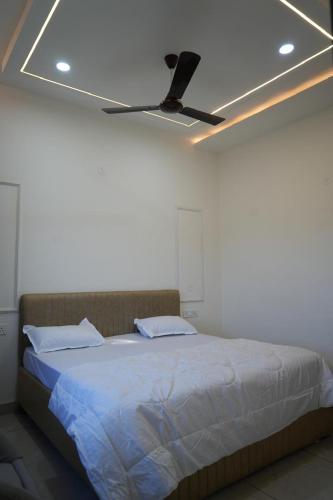 a bedroom with a bed with a ceiling fan at Hotel Griffin in Kīratpur