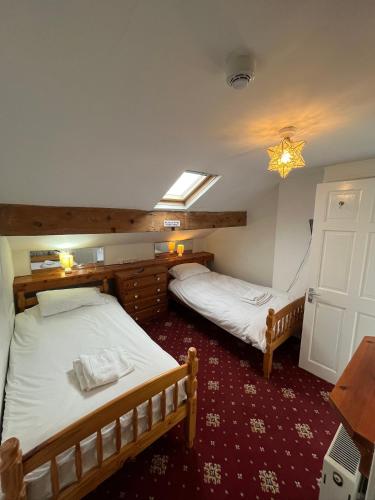 two twin beds in a room with a window at Marston town centre villa in Blackpool