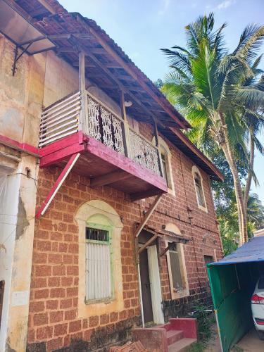an old house with a balcony on top of it at Vikram homestay in Malvan