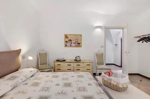 a bedroom with a bed and two chairs and a dresser at Al Castello Residenza D'Epoca in Pietra Ligure