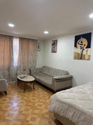 a living room with a couch and a table at sofia guest house in Chiatʼura