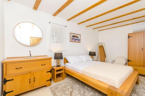 a bedroom with a bed and a sink and a mirror at House Bilusic in Poljica