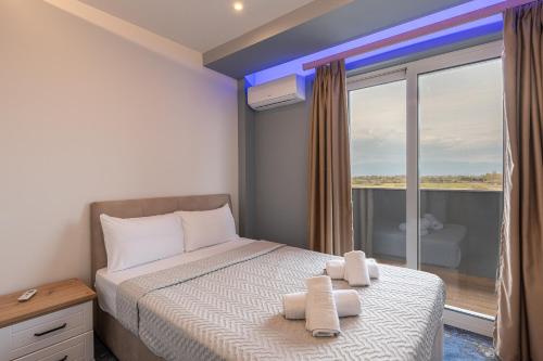 a bedroom with a bed and a large window at Poseidon 5 in Paralia Katerinis