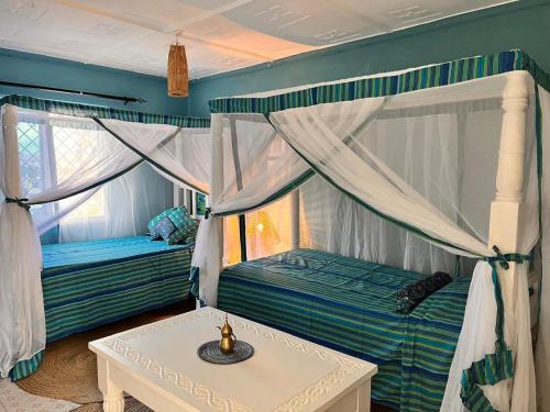 a bedroom with two bunk beds and a table at Khangadelic Kilifi in Kilifi