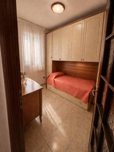 a small bedroom with a bed and a desk in it at La Casa Serena in Scalea