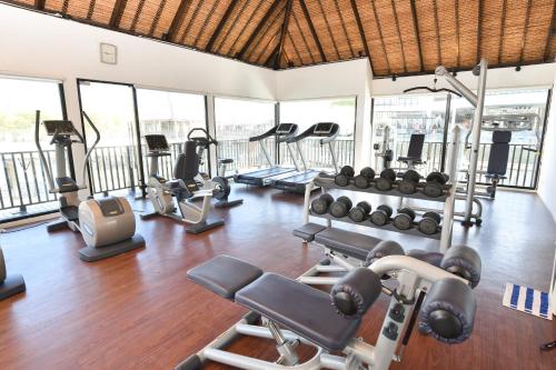 a gym with several treadmills and exercise machines at Avani Sepang Goldcoast Resort in Sepang