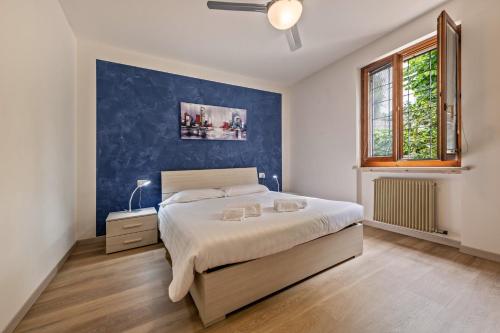a bedroom with a bed and a blue wall at Casa Tuly in Brenzone sul Garda