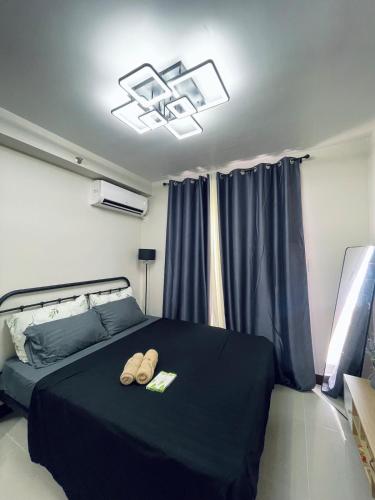 a bedroom with a bed with two slippers on it at Saekyung Marigondon in Suba