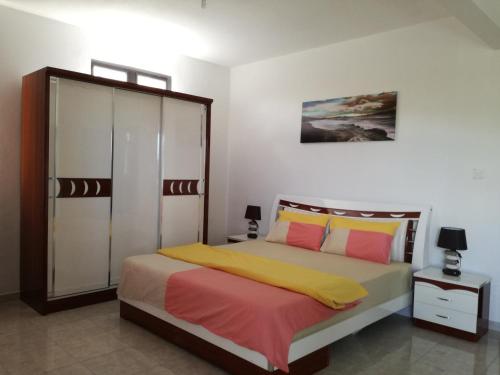 a bedroom with a bed with yellow and pink at Happy Villa in Trou aux Biches