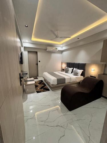 ein Hotelzimmer mit einem Bett und einer Couch in der Unterkunft Hotel Pine Ville in Ahmedabad