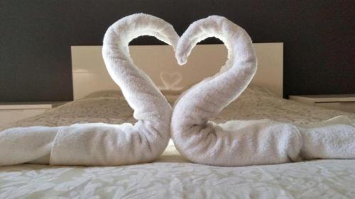 two swans shaped like a heart sitting on a bed at Perth City Apartment Hotel in Perth