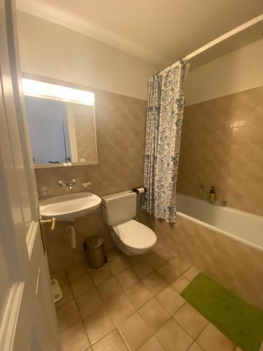 a bathroom with a toilet and a sink and a tub at Flat 12-min walk to Bern station in Bern