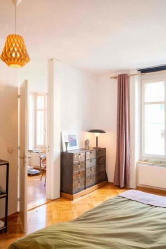 a bedroom with a bed and a dresser and window at Flat 12-min walk to Bern station in Bern